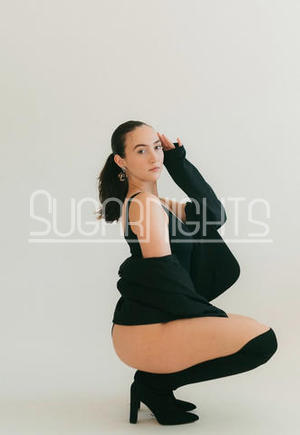 Coco in Kansas City posing in a black bodysuit and high heels.